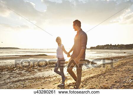 Young couple walking on beach View Large Photo Image Stock Image - Young couple walking on beach. Fotosearch