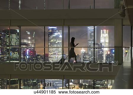 Young woman using smartphone and pulling suitcase, city skyline in view View Large Photo Image Stock Photography - Young woman using smartphone and pulling suitcase, city skyline in view. Fotosearch