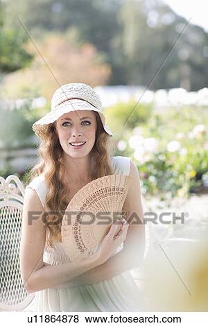 Young woman with hand fan View Large Photo Image Stock Photo - Young woman with hand fan. Fotosearch