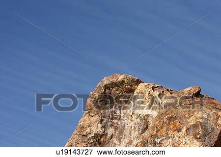 Stock Photo - Low angle view of rock cliff. Fotosearch