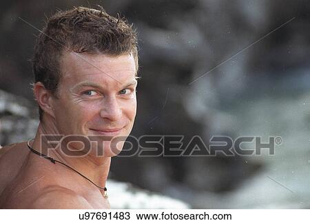 Stock Image - Surfer looking at camera. Fotosearch