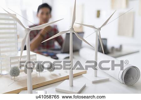 Stock Photography - architect in background, Wind turbine models on desk. Fotosearch
