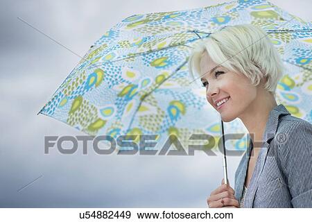 Stock Photo - Blonde woman under umbrella. Fotosearch