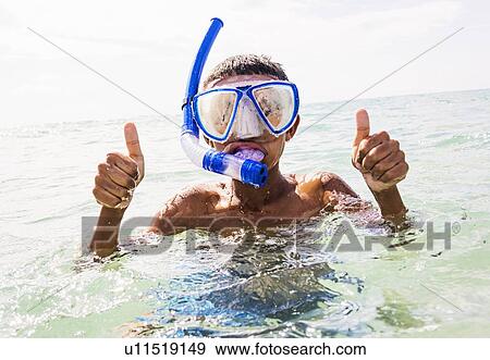 Stock Photo - Boy (10-11) snorkeling in sea. Fotosearch