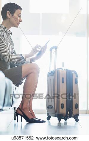 Businesswoman at the airport using tablet View Large Photo Image Stock Image - Businesswoman at the airport using tablet. Fotosearch