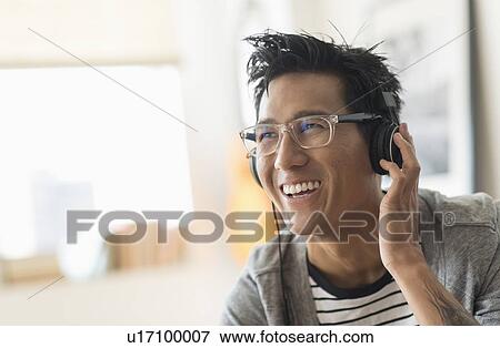 Cheerful man listening to music View Large Photo Image Stock Photo - Cheerful man listening to music. Fotosearch