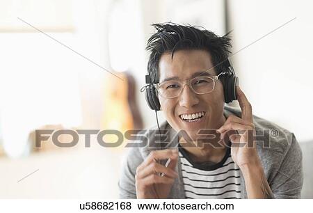 Cheerful man listening to music View Large Photo Image Stock Photo - Cheerful man listening to music. Fotosearch