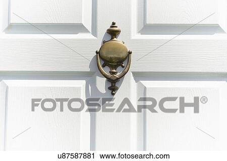 Stock Image - Close-up of white door with knocker. Fotosearch