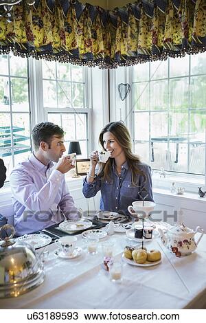 Stock Image - Couple eating together in dining room. Fotosearch