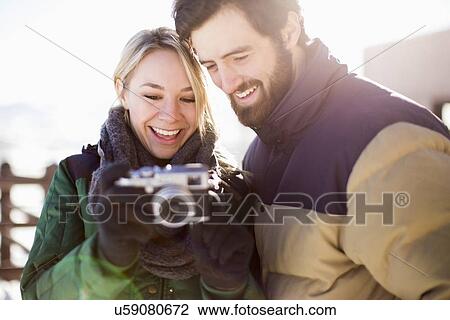 Stock Image - Couple looking at old-fashioned camera. Fotosearch