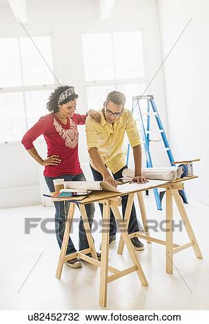 Stock Image - Couple preparing for renovation of new home. Fotosearch