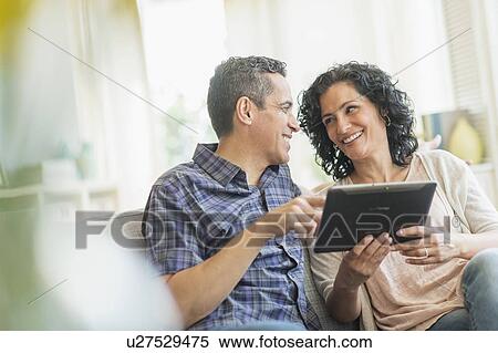Couple using digital tablet View Large Photo Image Stock Photography - Couple using digital tablet. Fotosearch