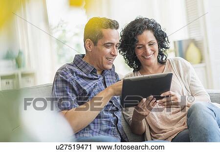 Couple using digital tablet together View Large Photo Image Stock Image - Couple using digital tablet together. Fotosearch