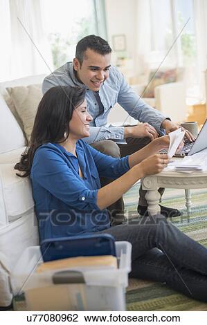 Couple working in living room View Large Photo Image Stock Image - Couple working in living room. Fotosearch