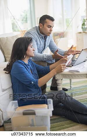 Stock Photography - Couple working in living room. Fotosearch