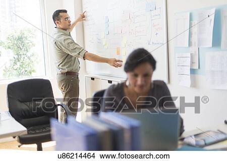Picture - Couple working in office. Fotosearch