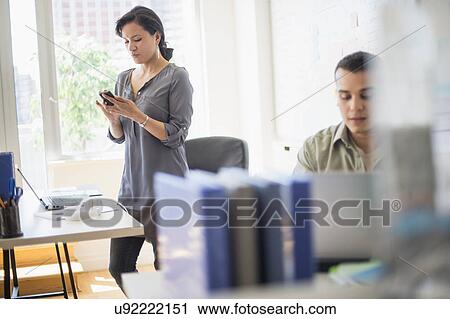 Stock Image - Couple working in office. Fotosearch