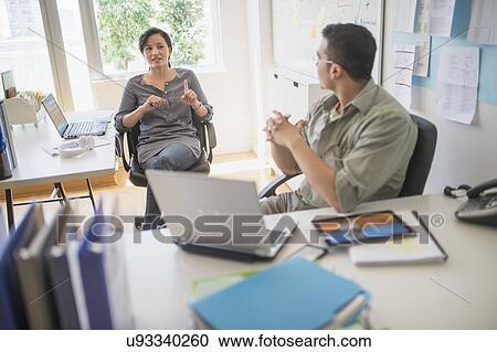 Stock Image - Couple working in office. Fotosearch
