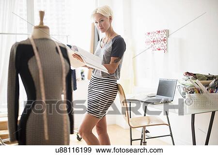 Designer looking at sketchbook in studio View Large Photo Image Stock Photo - Designer looking at sketchbook in studio. Fotosearch