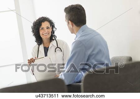 Stock Image - Doctor talking with patient. Fotosearch
