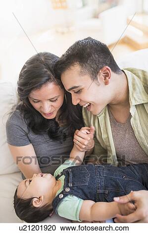 Stock Image - Family with baby son (6-11 months) in living room. Fotosearch
