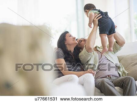 Stock Image - Family with baby son (6-11 months) in living room. Fotosearch