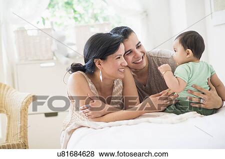 Family with baby son (6-11 months) in bedroom View Large Photo Image Stock Photo - Family with baby son (6-11 months) in bedroom. Fotosearch