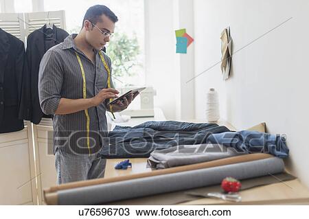Stock Image - Fashion designer in his studio. Fotosearch