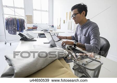 Stock Photo - Fashion designer working in studio. Fotosearch