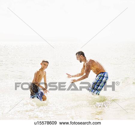 Father and son (10-11) having fun on beach View Large Photo Image Stock Photo - Father and son (10-11) having fun on beach. Fotosearch