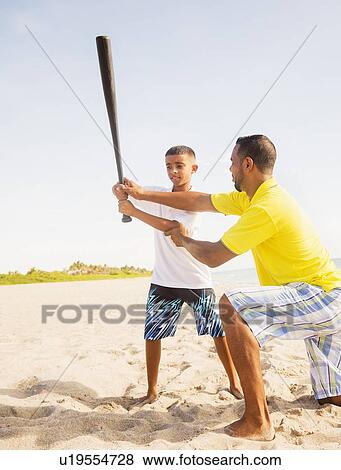 Father and son (10-11) playing baseball on beach View Large Photo Image Stock Photo - Father and son (10-11) playing baseball on beach. Fotosearch