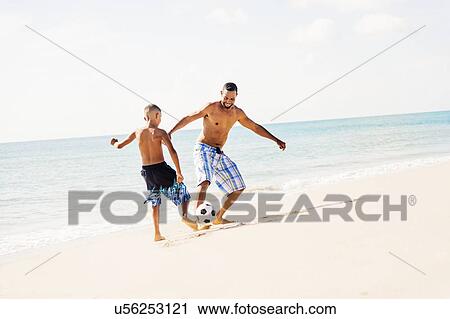 Father and son (10-11) playing soccer on beach View Large Photo Image Stock Image - Father and son (10-11) playing soccer on beach. Fotosearch