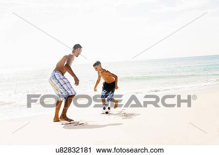 Father and son (10-11) playing soccer on beach View Large Photo Image Stock Image - Father and son (10-11) playing soccer on beach. Fotosearch