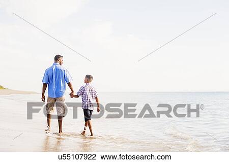 Father and son (10-11) walking on beach View Large Photo Image Stock Image - Father and son (10-11) walking on beach. Fotosearch