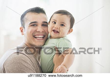 Stock Image - Father holding his son (6-11 months). Fotosearch