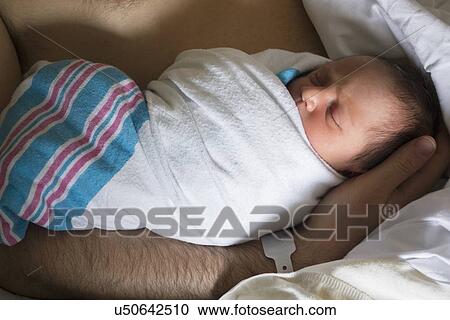 Stock Image - Father holding newborn daughter. Fotosearch