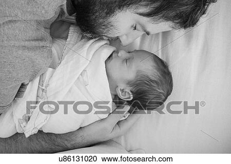 Stock Image - Father holding newborn daughter. Fotosearch