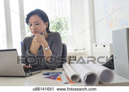 Stock Image - Female architect working with laptop. Fotosearch