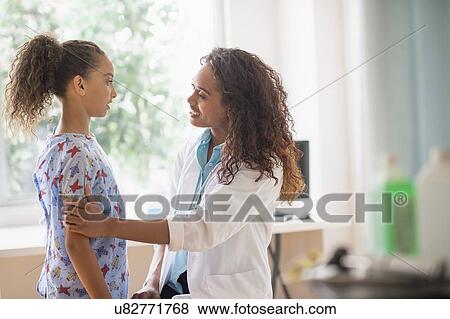 Stock Photo - Female doctor examining girl (8-9). Fotosearch