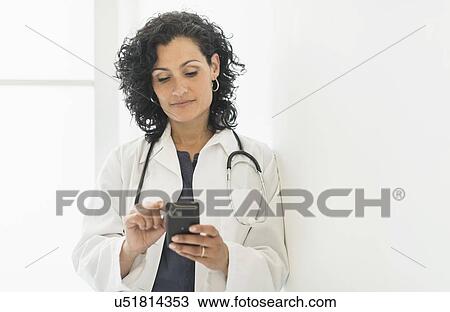 Female doctor using cell phone View Large Photo Image Stock Image - Female doctor using cell phone. Fotosearch