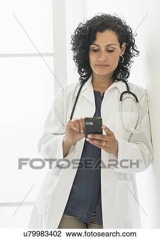 Female doctor using cell phone View Large Photo Image Stock Image - Female doctor using cell phone. Fotosearch