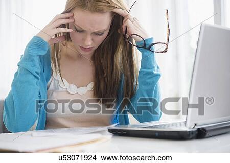 Frustrated young woman looking at bills View Large Photo Image Picture - Frustrated young woman looking at bills. Fotosearch