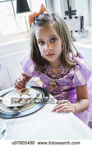 Girl (4-5) eating cookies at dining table View Large Photo Image Stock Image - Girl (4-5) eating cookies at dining table. Fotosearch