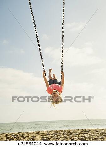 Picture - Girl (4-5) swinging on beach. Fotosearch
