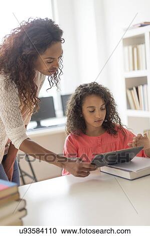 Girl (8-9) and teacher using digital tablet in classroom View Large Photo Image Stock Image - Girl (8-9) and teacher using digital tablet in classroom. Fotosearch