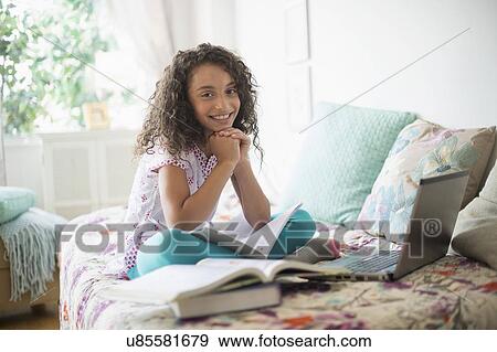 Girl (8-9) studying on bed View Large Photo Image Stock Photo - Girl (8-9) studying on bed. Fotosearch