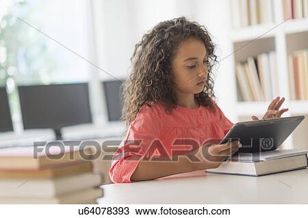 Girl (8-9) using digital tablet in classroom View Large Photo Image Stock Image - Girl (8-9) using digital tablet in classroom. Fotosearch