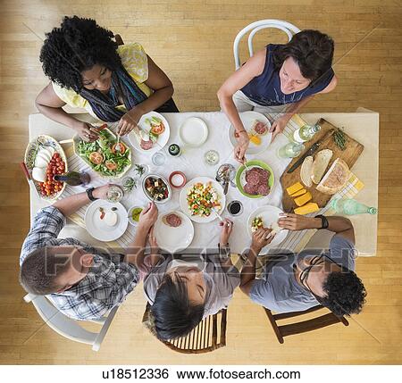 Stock Photograph - Group of friends dining together. Fotosearch