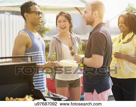Group of friends enjoying barbeque View Large Photo Image Stock Image - Group of friends enjoying barbeque. Fotosearch