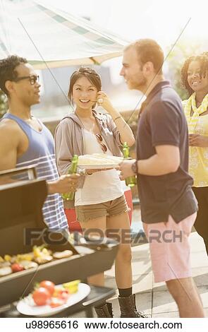 Stock Photograph - Group of friends enjoying barbeque. Fotosearch